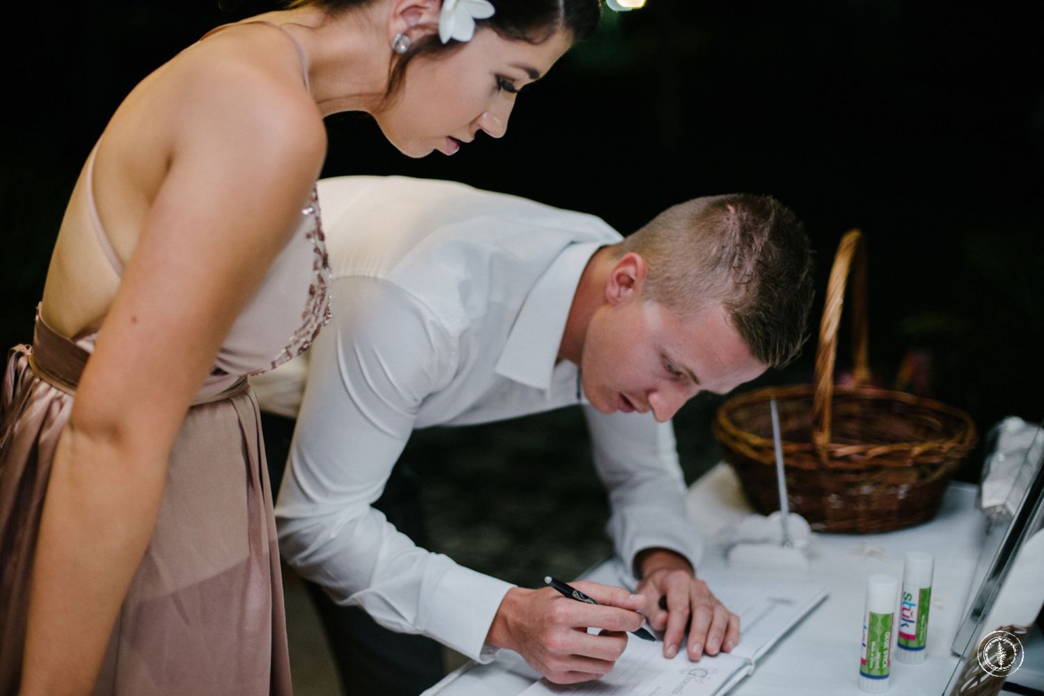 Signing of wedding documents at reception with decorative pen and paperwork.