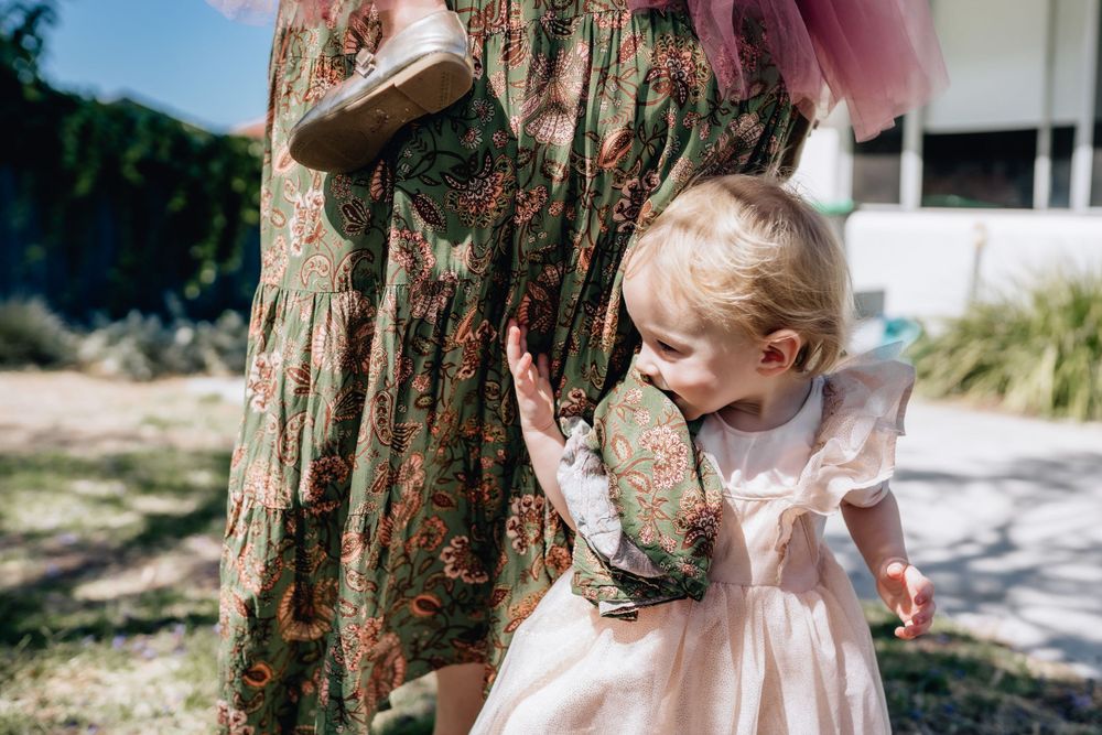 Motherhood- a toddler holding on to her mum’s leg