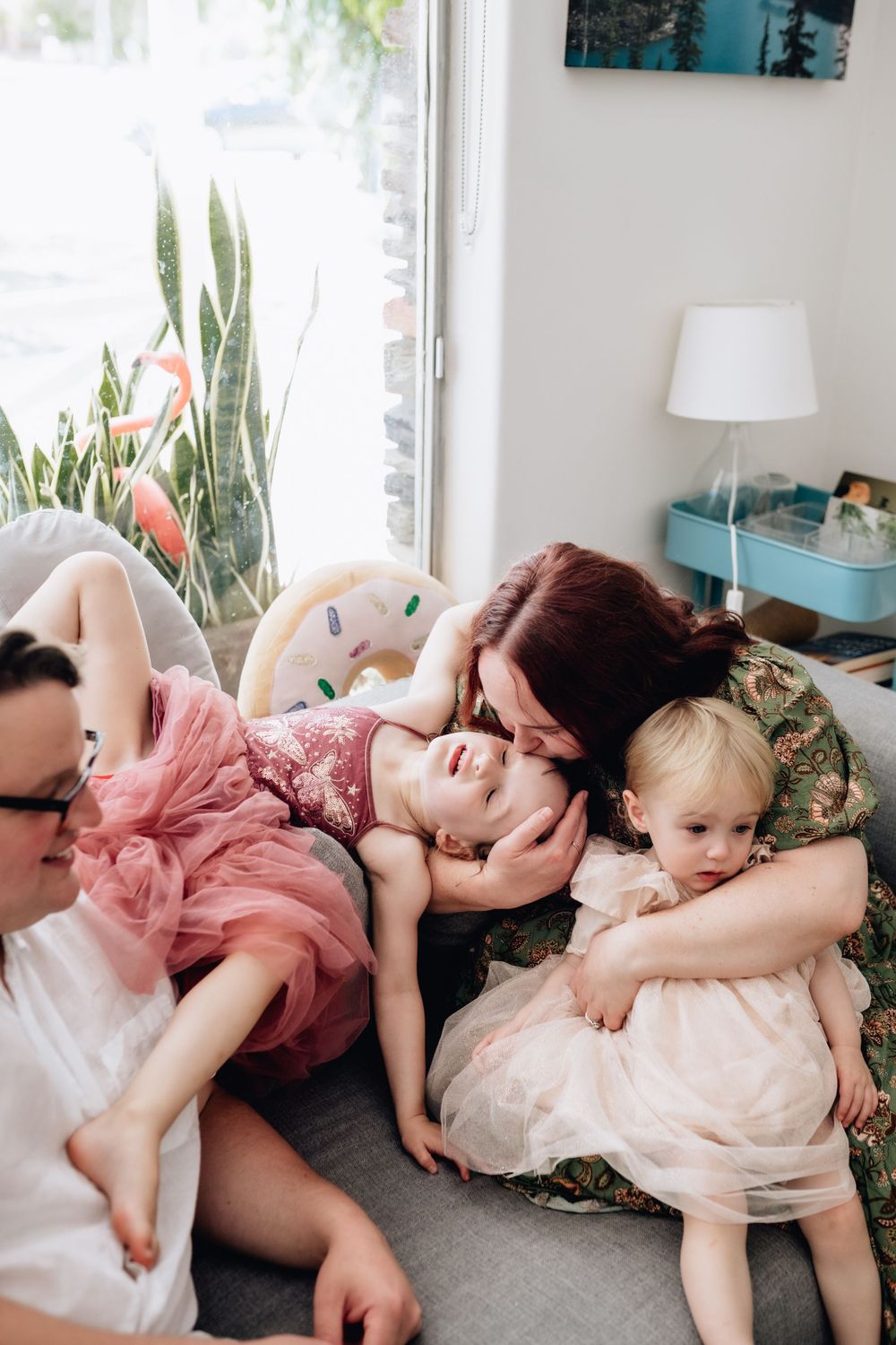 A mum cuddling her daughters while the Dad watches