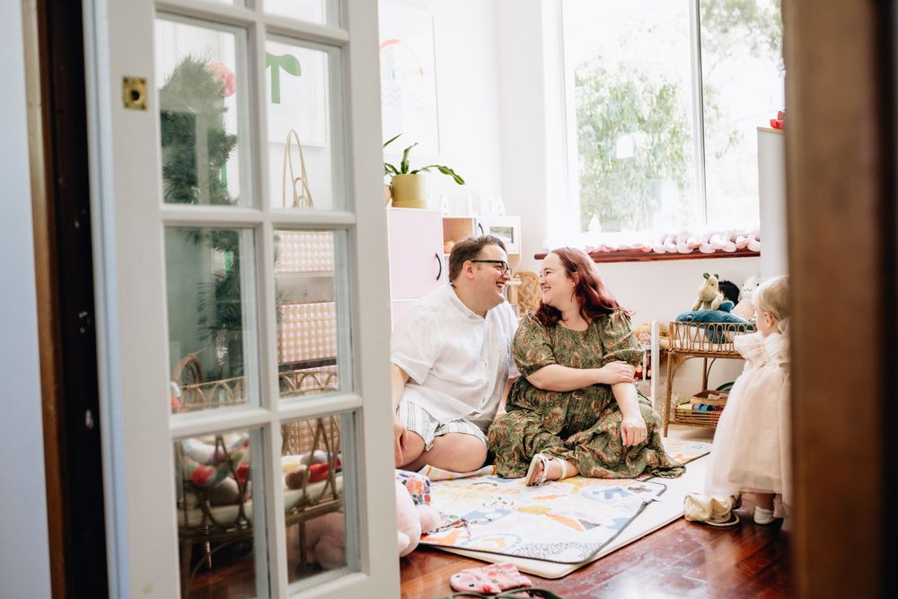 A man and woman sitting in their family room in Perth, looking at each other