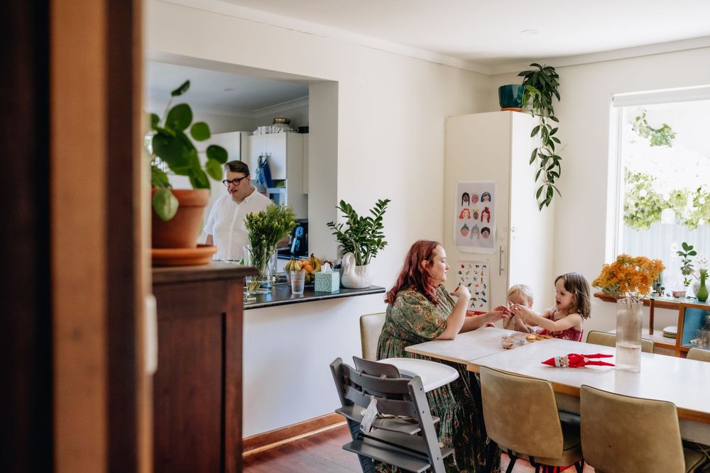 A mum sitting at the dining table with her two daughters during morning tea