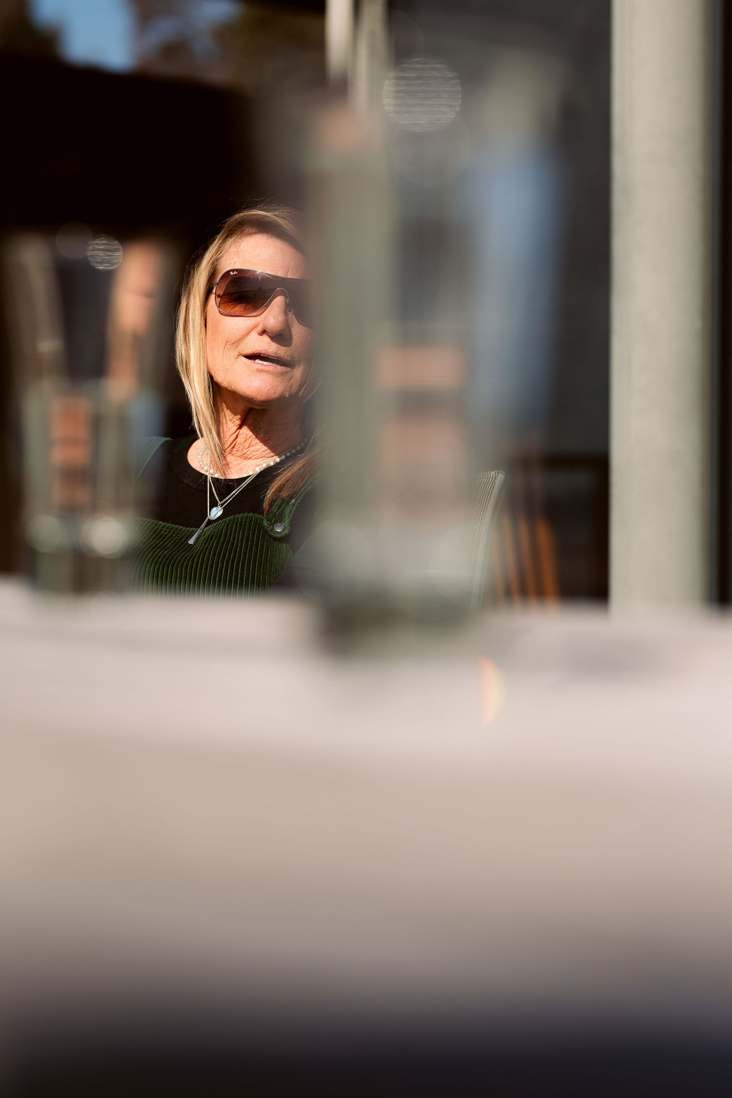 Person wearing sunglasses reflected in a window or mirror.
