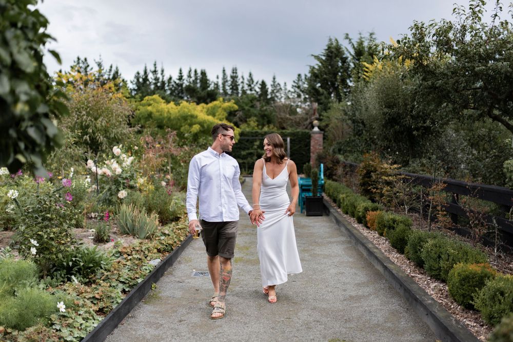 bride and groom portrait walking down a path in the garden