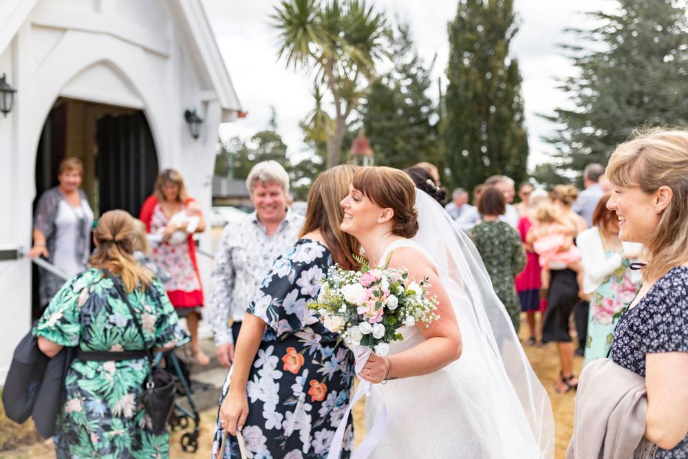 bride hugging a friend with her bouquet