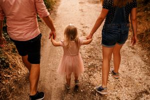 A sweet walking moment captured from behind on a dirt path.