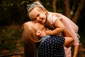 A sweet embrace captured in a forest setting with polka dots and pink tulle.
