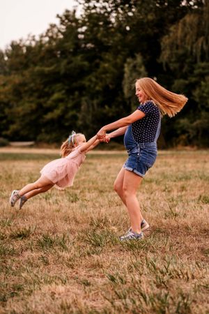 A playful spinning moment captured in a grassy meadow on a warm summer evening.