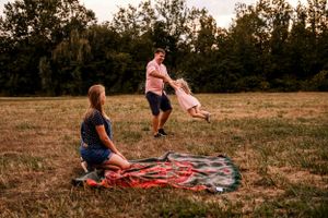 A fun afternoon of play and laughter on a picnic blanket in a sunlit field.