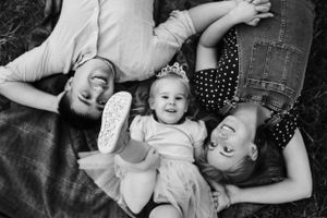 A black and white portrait of pure joy and laughter while laying on a blanket.