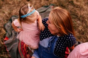 Casual outdoor portrait featuring pink and navy blue outfits against a natural background.