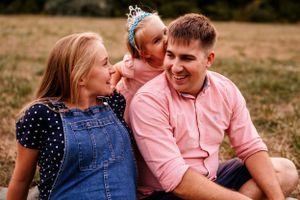 A happy family shares a joyful moment together outdoors during golden hour.