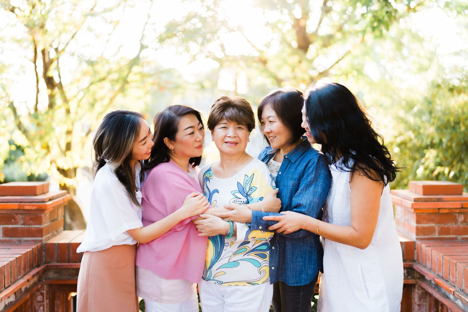 A group of friends sharing joyful laughter together on a sunny outdoor patio.