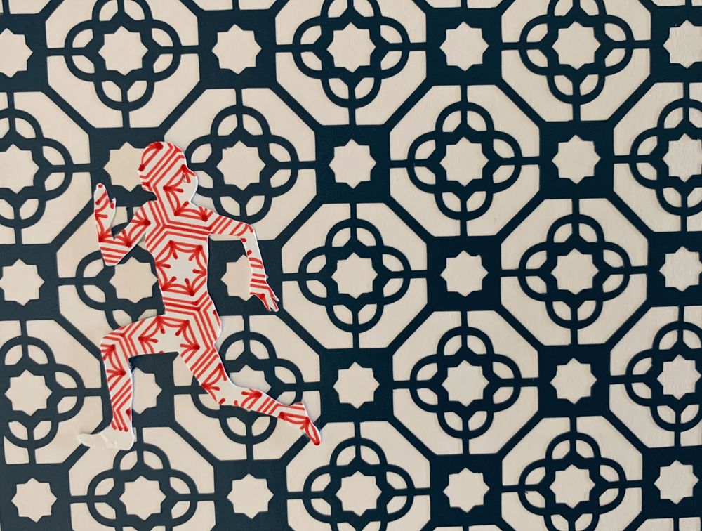 Red geometric figure against black and white decorative tile pattern background.