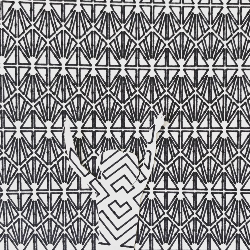 Black and white geometric pattern with intricate art deco style repetitive angular designs.