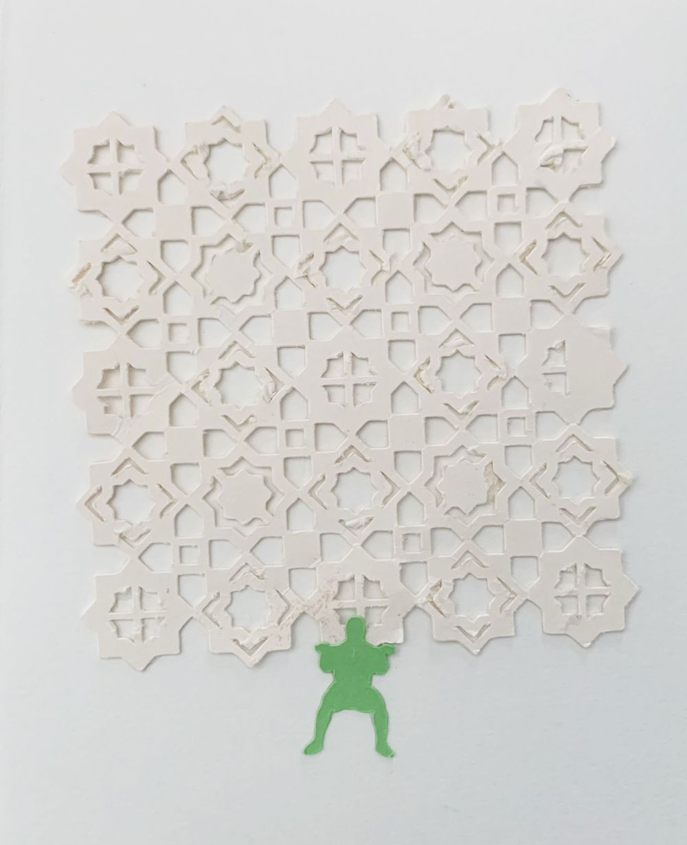 Intricate white geometric pattern made of paper cutouts with a small green figure silhouette at the bottom.
