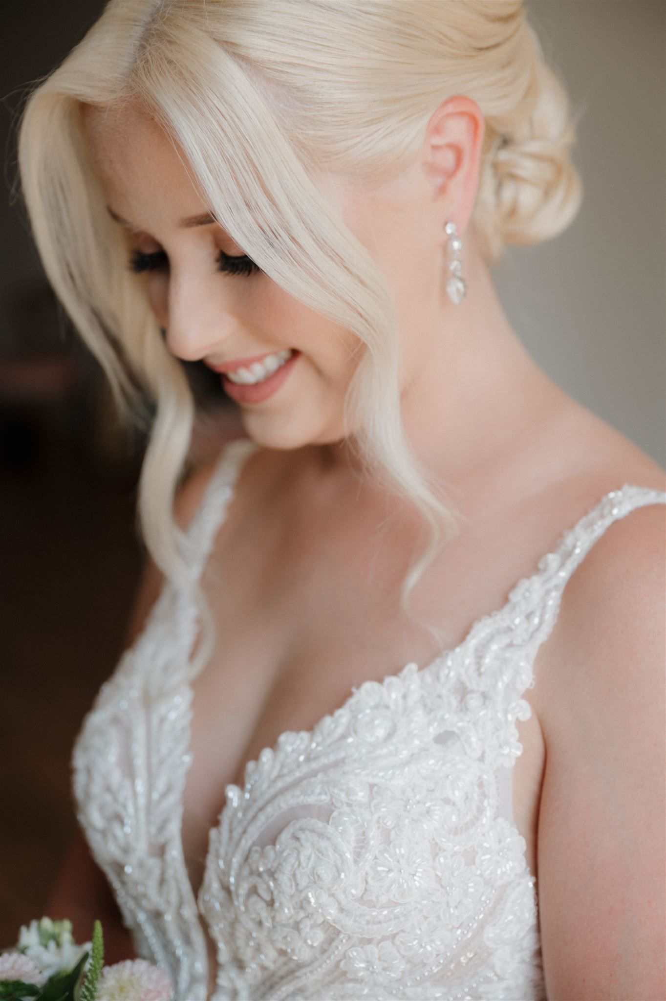A delicate lace wedding dress with intricate beading and a graceful neckline captured in soft light.