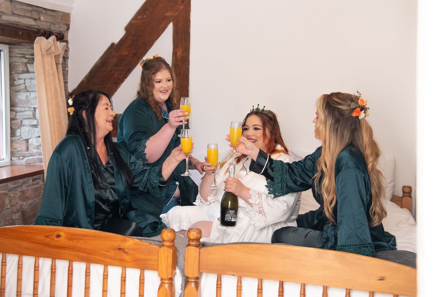 Bridesmaids in blue dresses prepare for wedding festivities while enjoying drinks together.