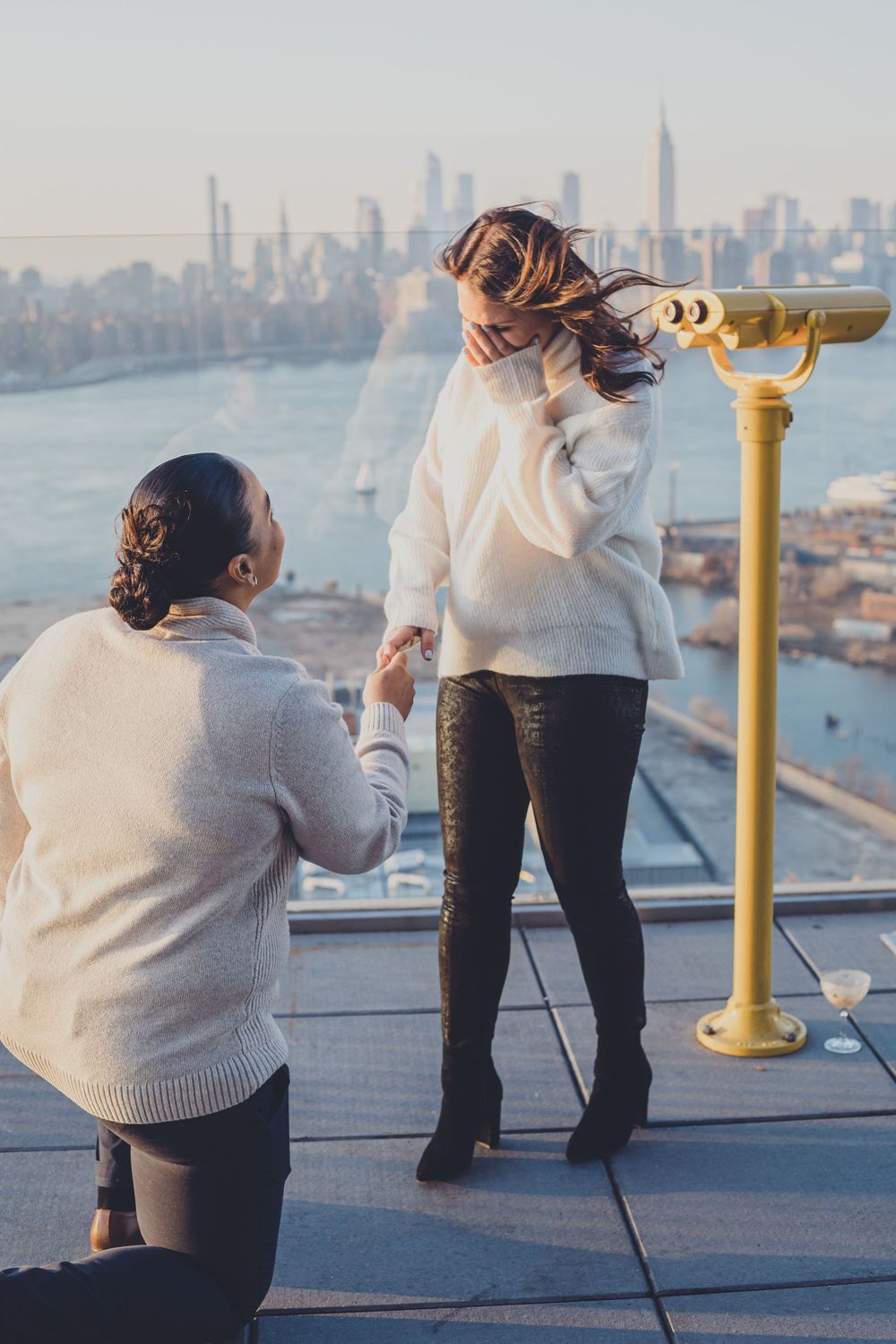 A proposal moment at an observation deck overlooking a city skyline.