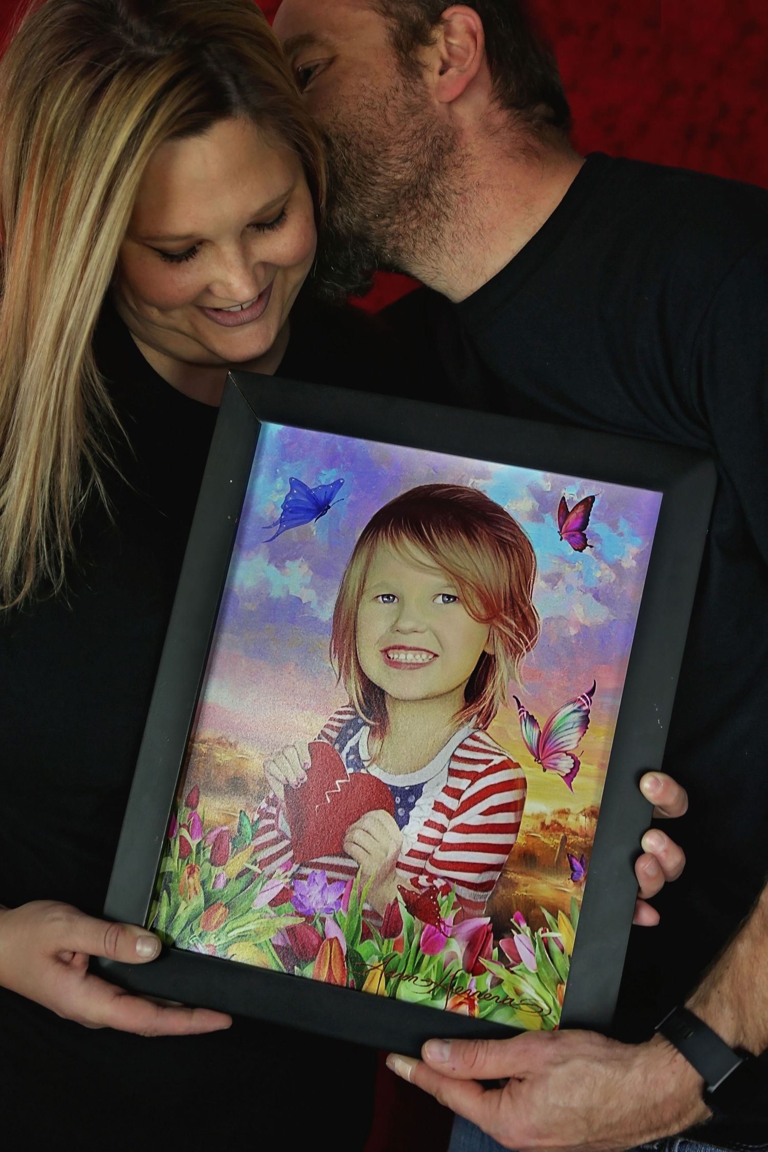 Mom and Dad missing their daughter as they hold her photo in their hands
