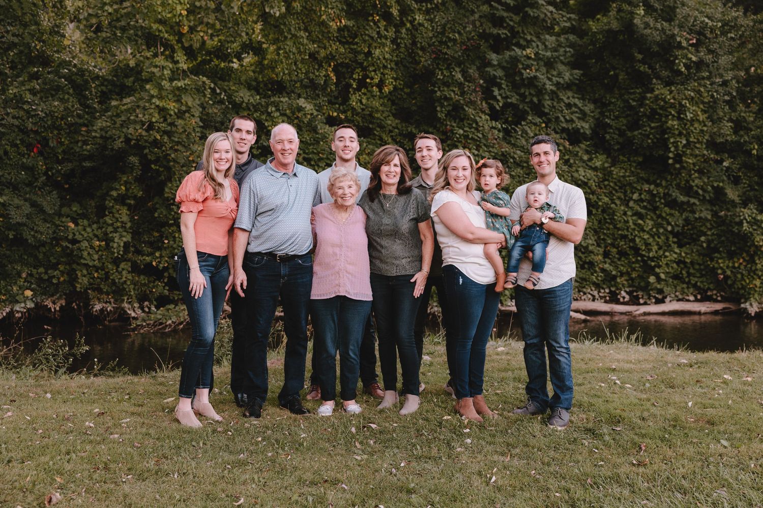 Large family group portrait outdoors with everyone wearing casual clothing.