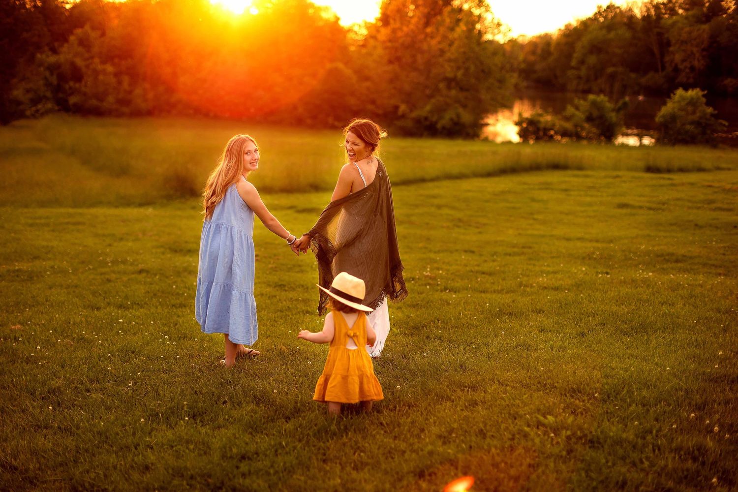 mother and daughter walking, looking over their shoulder at toddler