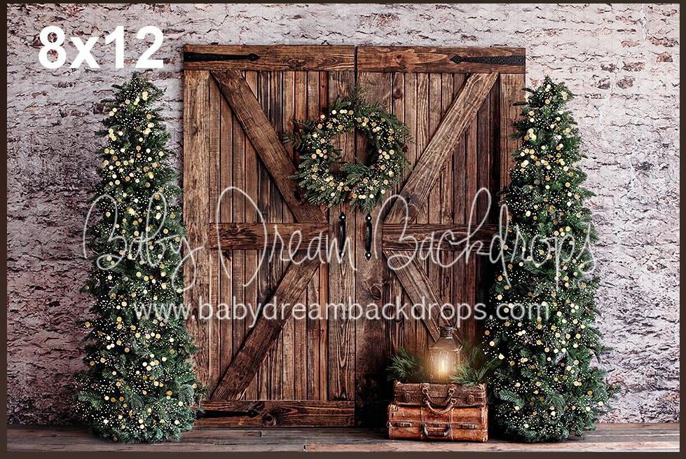 Rustic wooden barn door backdrop with evergreen garlands and wreath for holiday photography.