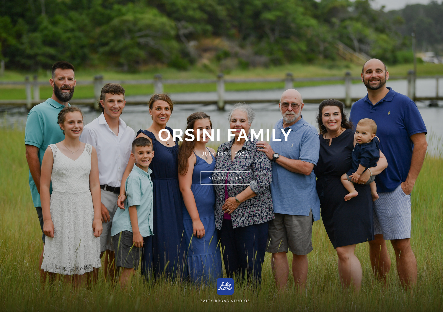 Extended family group portrait in casual attire against a natural outdoor backdrop.