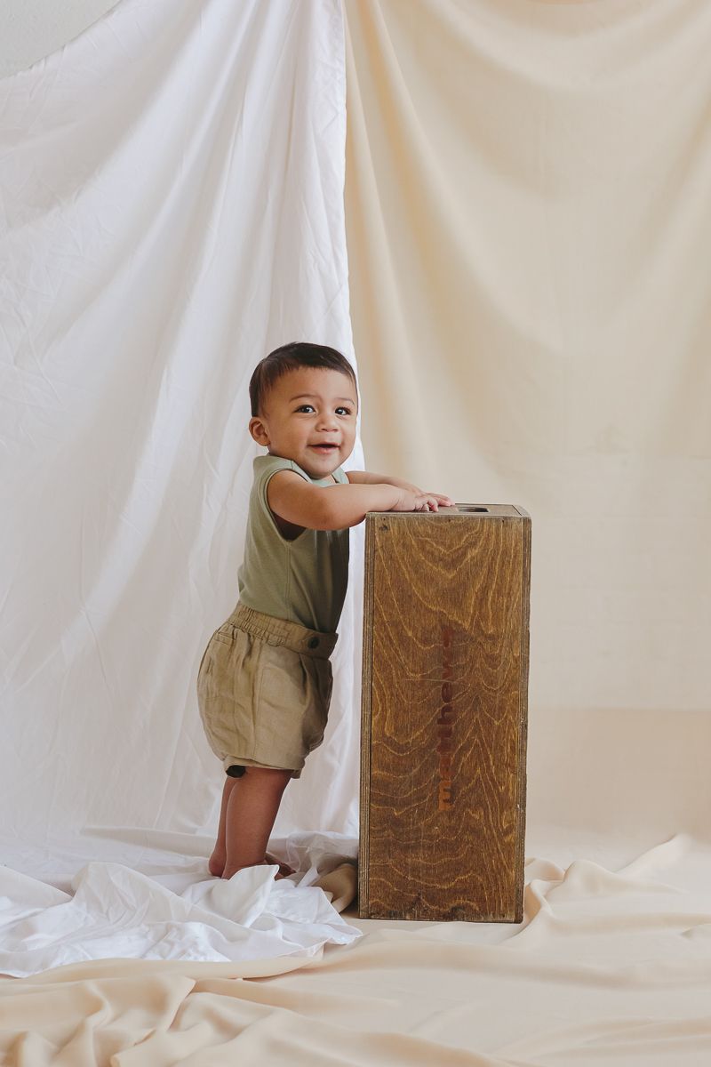 Baby Boy Stands Tall on Apple Box - NYC Studio Photography by Paula Ortiz