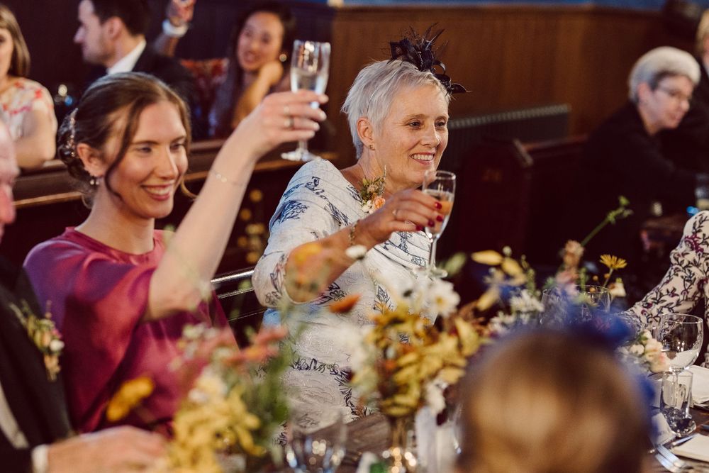 Celebratory atmosphere as guests raise their glasses during a formal dinner event.