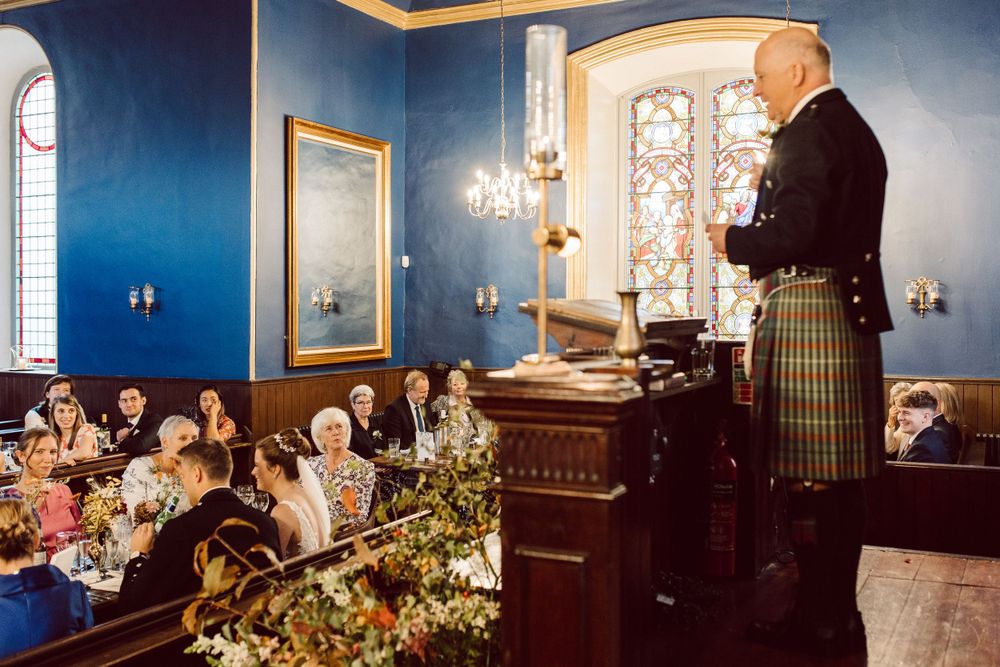 Elegant blue dining room with stained glass windows and crystal chandeliers set for a formal event.