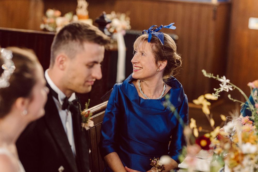 Wedding reception guests enjoying entertainment and speeches at decorated tables.