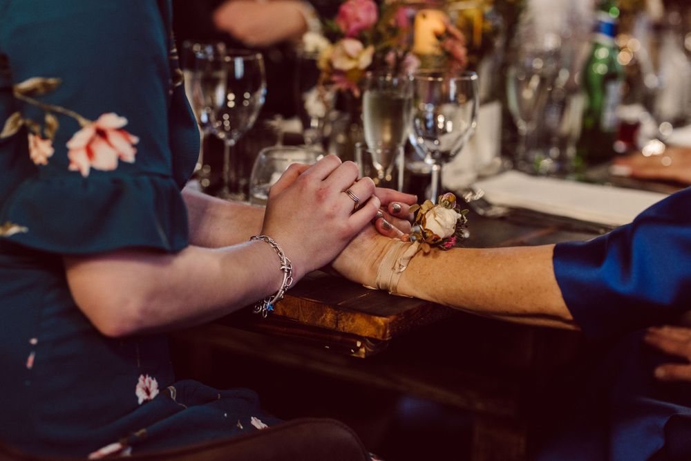 Close-up of elegant table settings with wine glasses and floral arrangements at a formal dinner.
