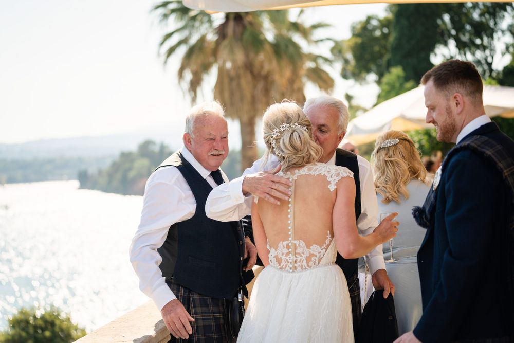 Wedding party poses together under palm trees at an elegant outdoor venue.