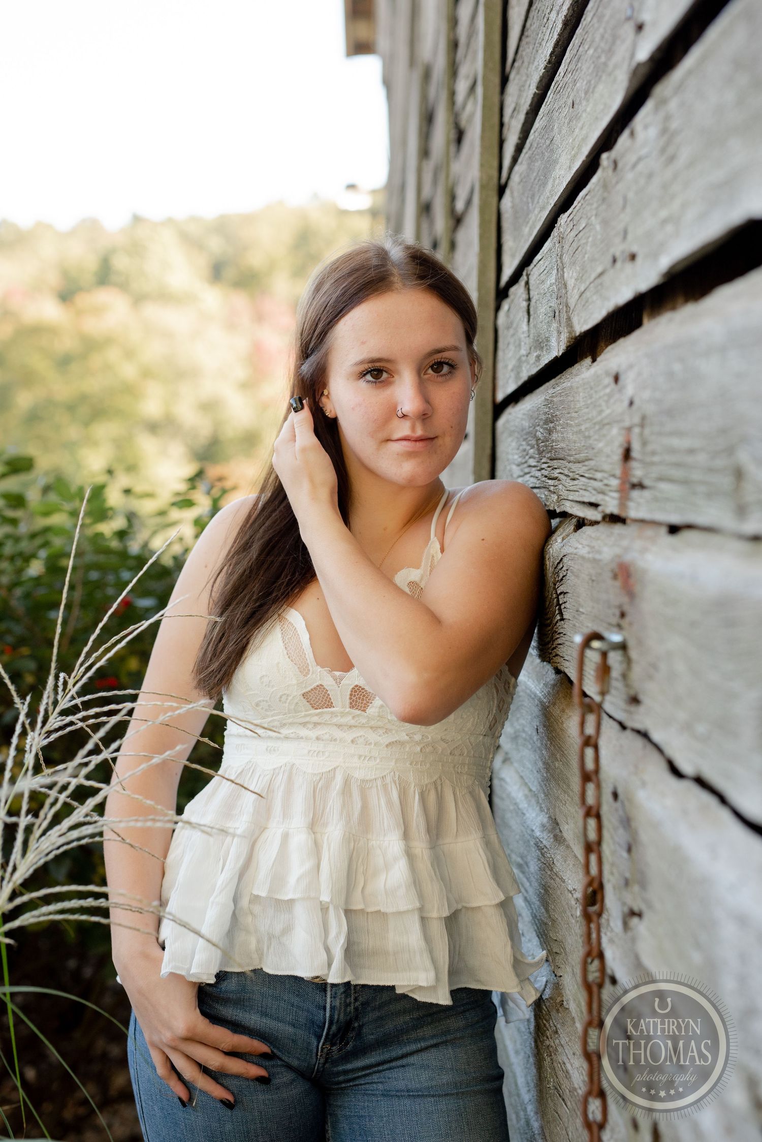 Casual outdoor portrait with rustic wooden background and soft natural lighting.