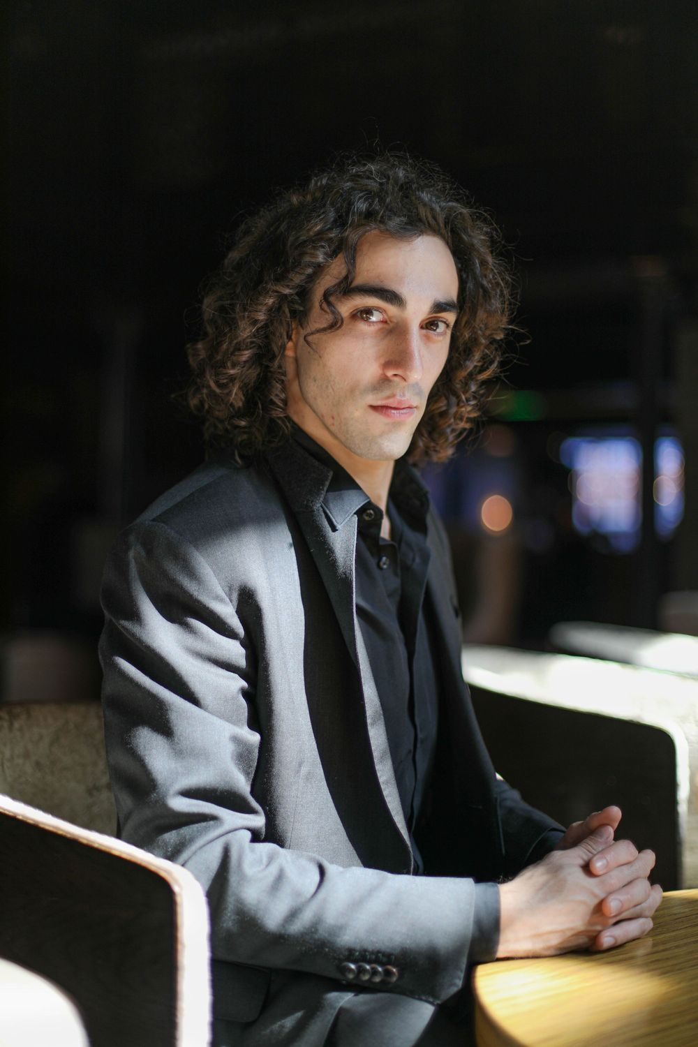 High contrast editorial shot of a man in business suit halfway in the light