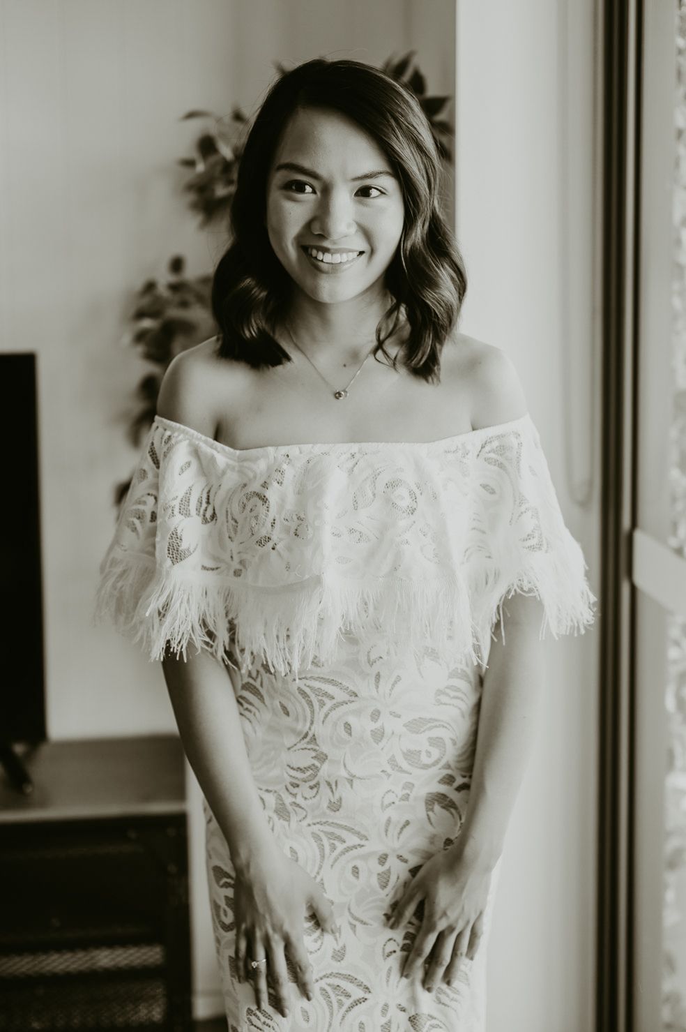 Portrait of a woman in an elegant off-shoulder lace dress.