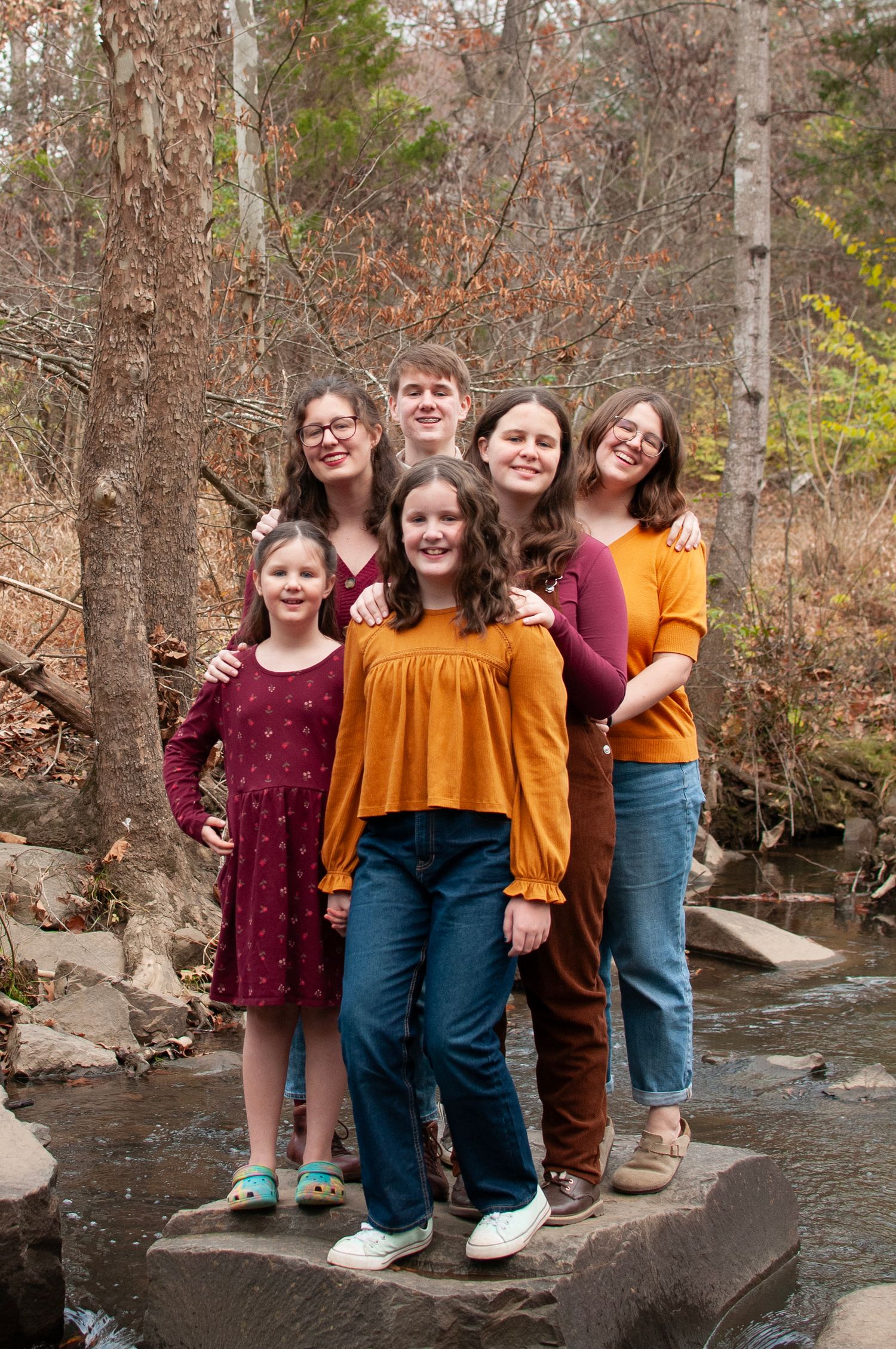 Siblings standing together on a rock midstream