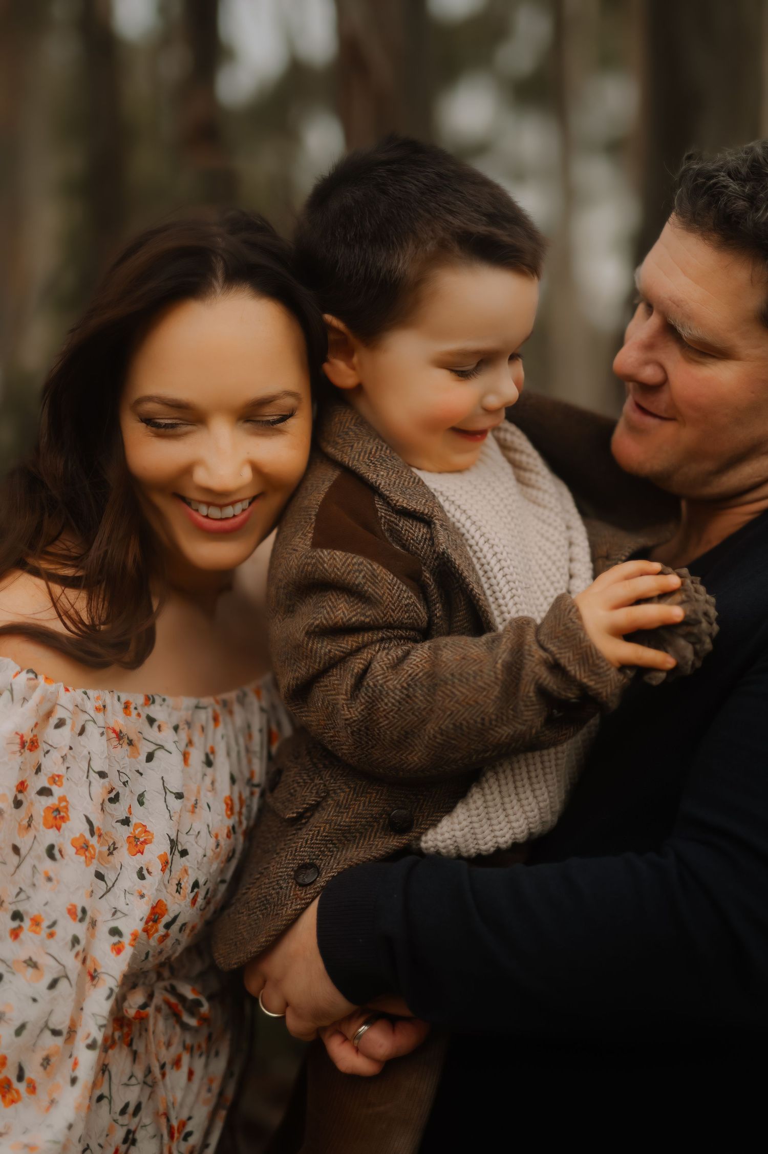 Joyful family moment captured in warm forest setting.