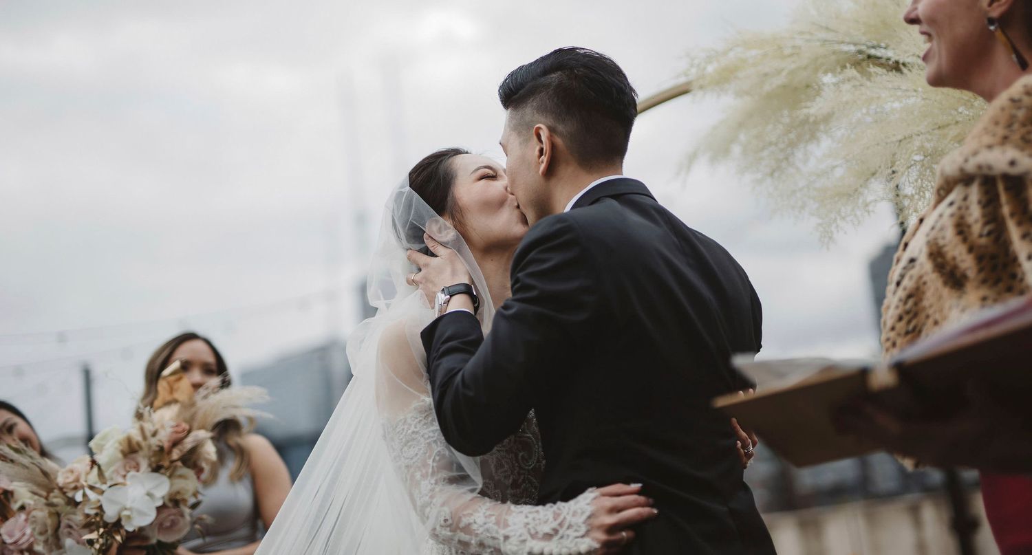 groom kissing his bride in garden wedding ceremony.
