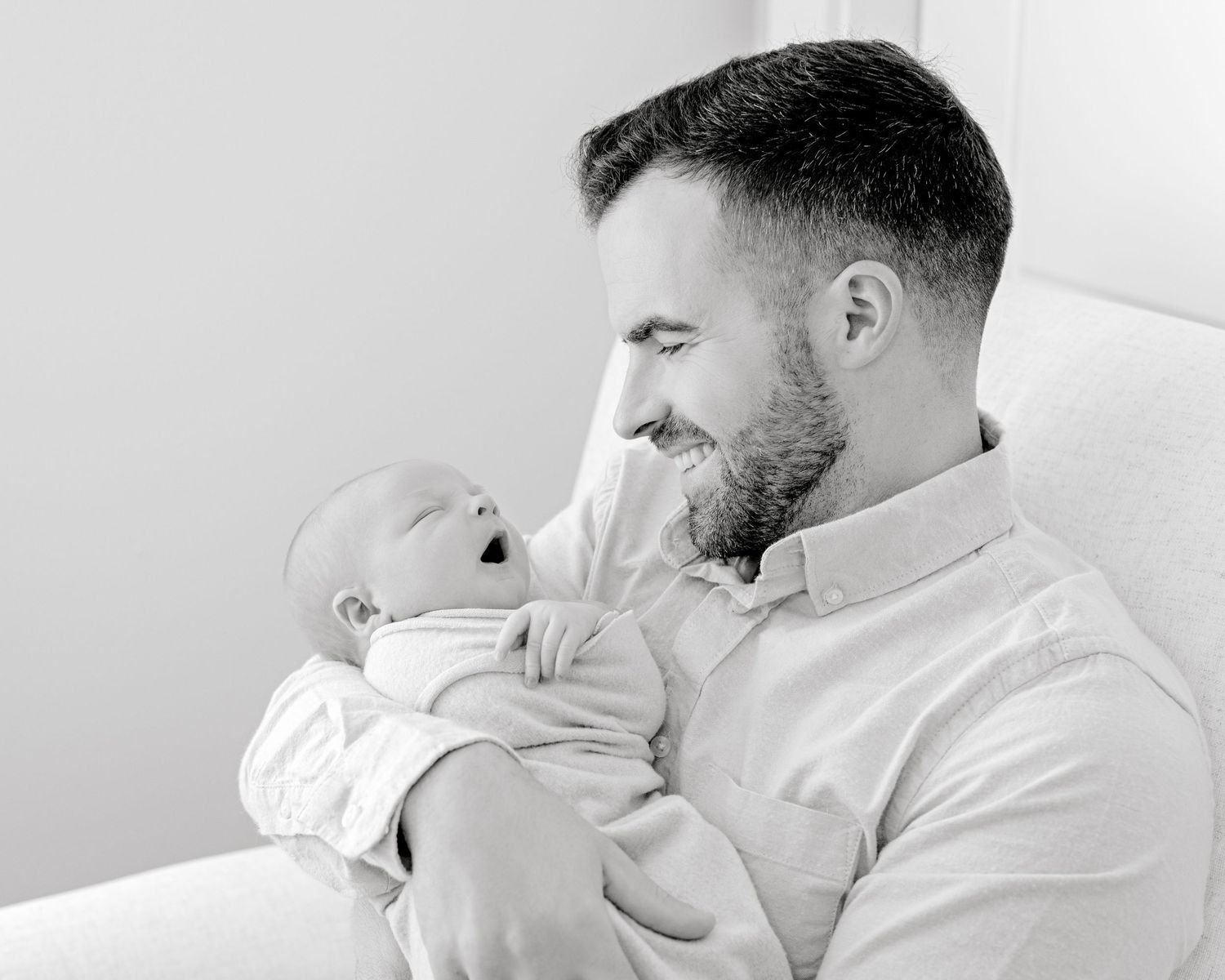 Black and white portrait capturing intimate bonding moment with infant.
