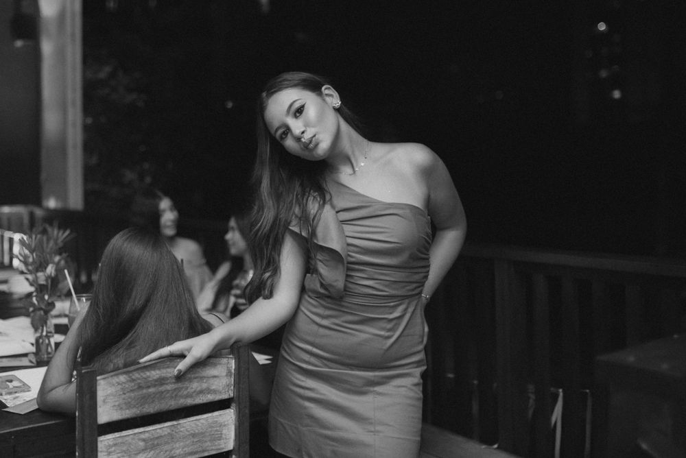 Black and white portrait of a person in a formal dress at an evening event.