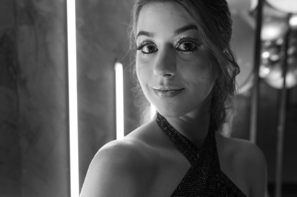 A black and white portrait featuring a halter dress and dramatic lighting.