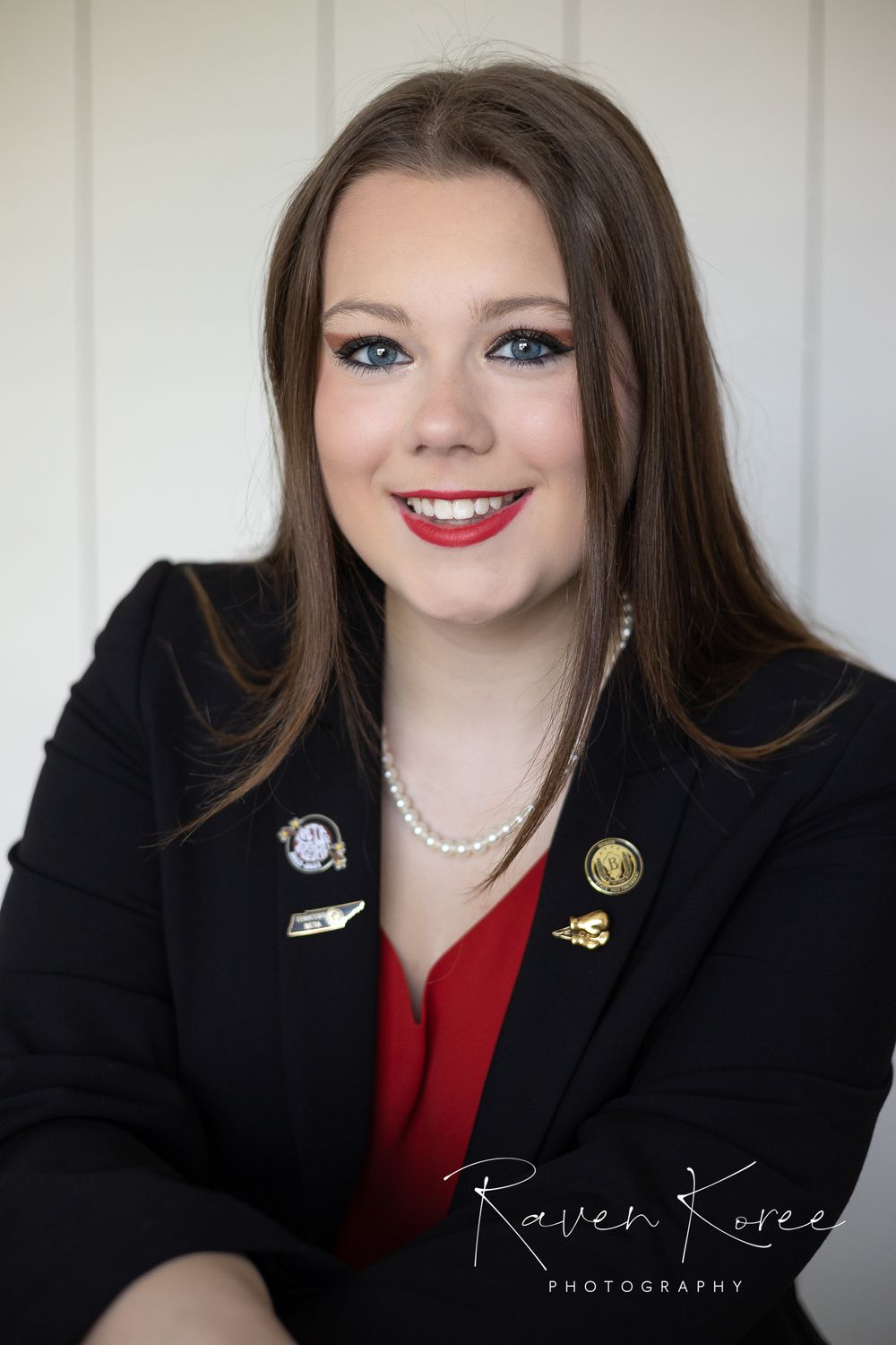 Young woman posing in front of a white wooden background for professional headshots