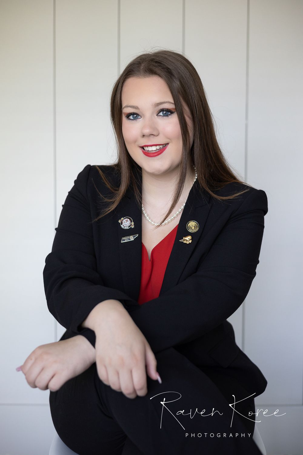 Young woman posing in front of a white wooden background for professional headshots