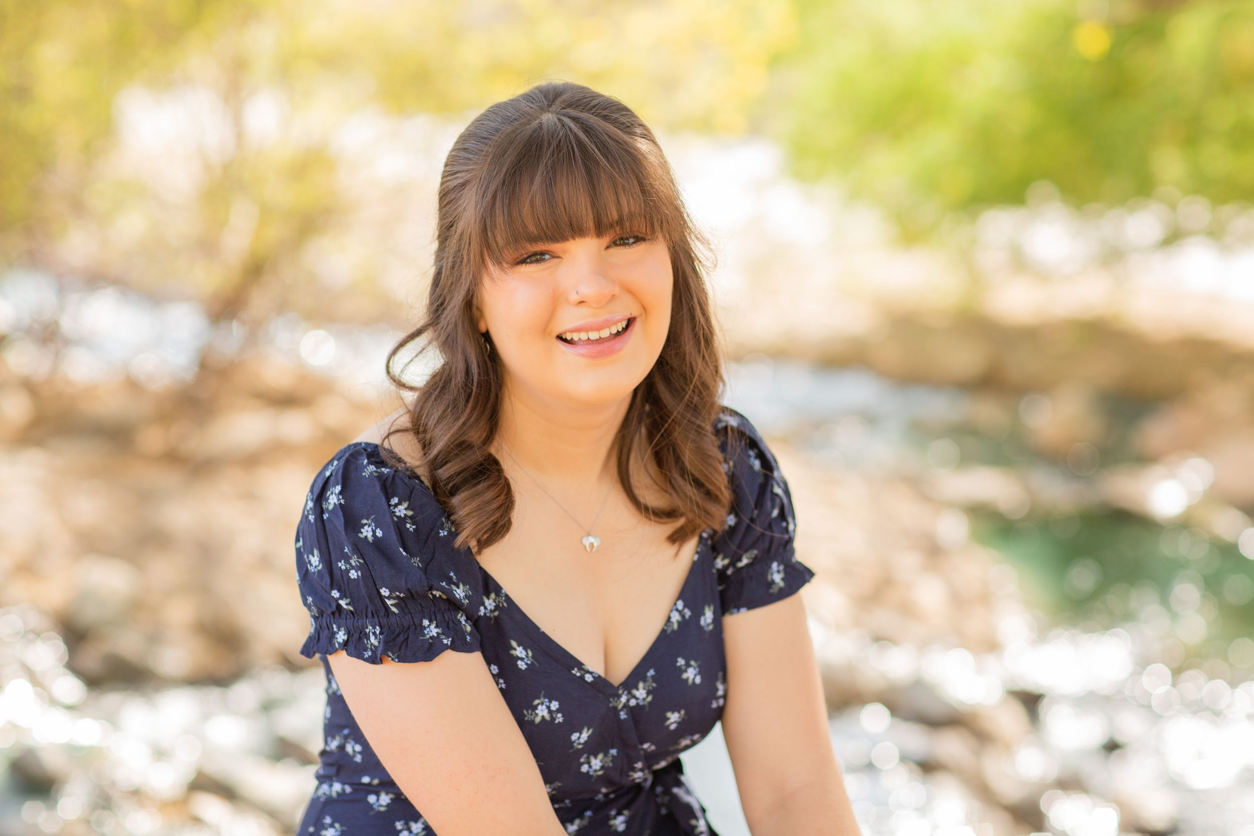 Portrait in floral navy dress against natural background.