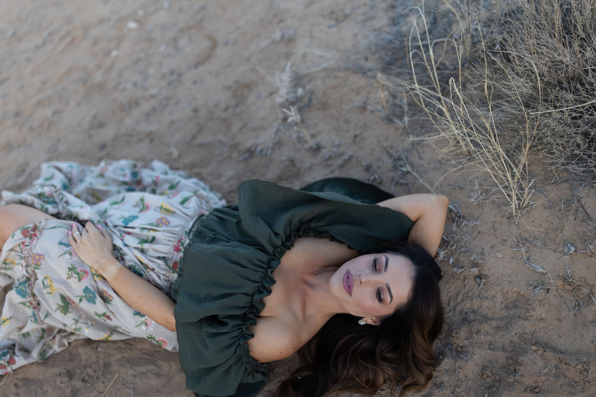 Dramatic portrait on red rocks with flowing dress and natural desert scenery.