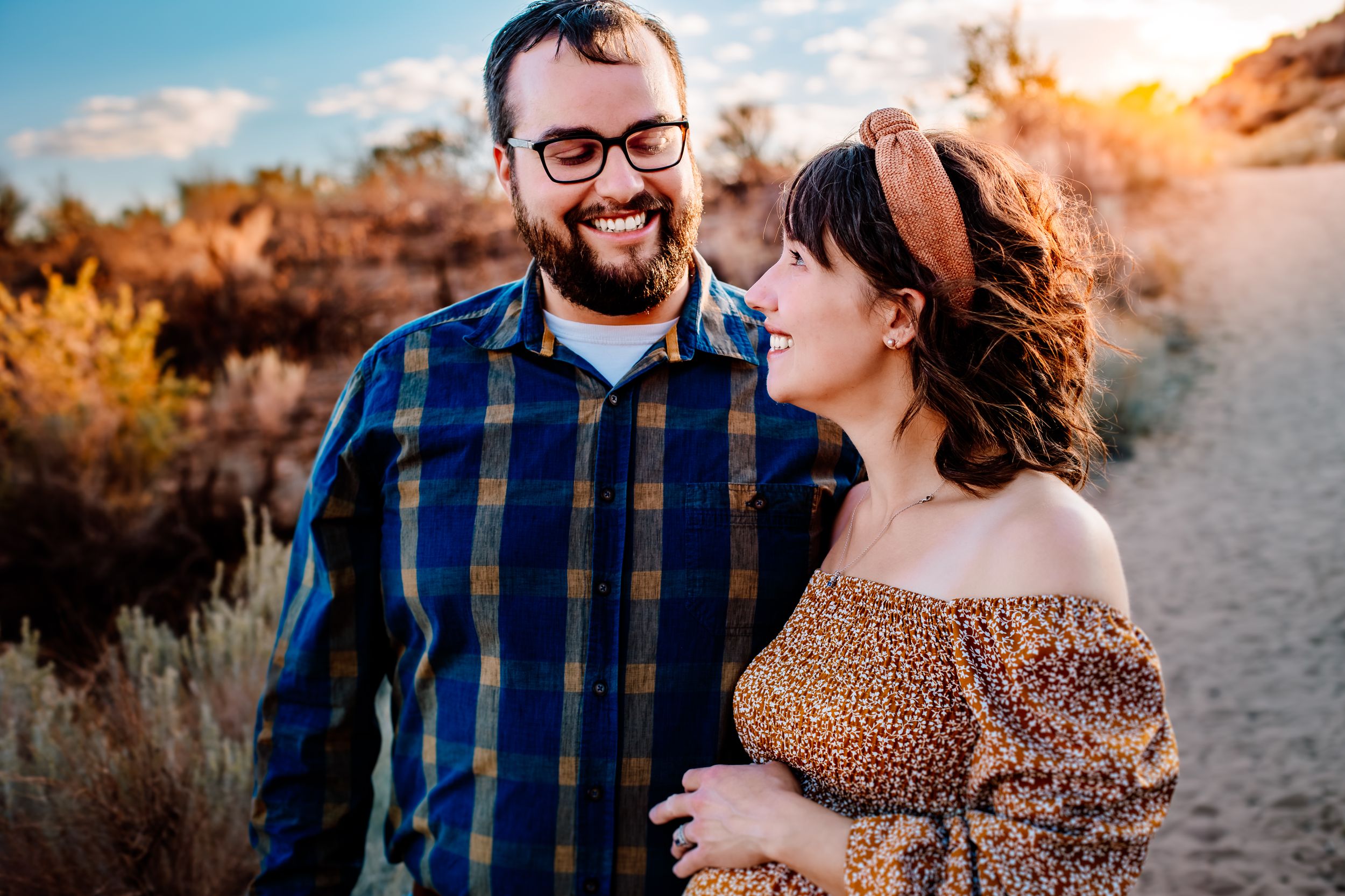 Romantic outdoor desert portrait at sunset with warm golden lighting and desert brush.