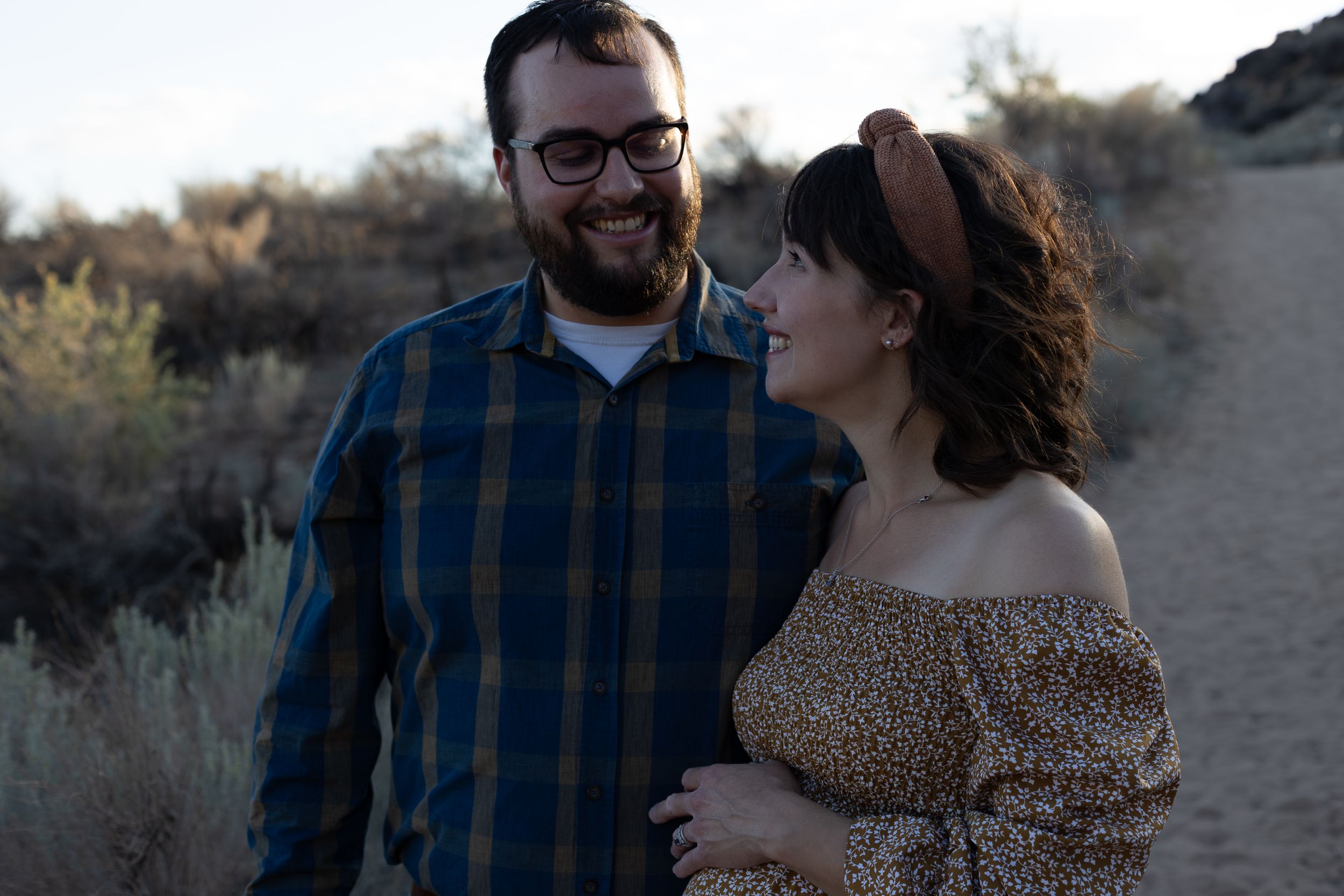 Intimate desert twilight portrait with desert sage brush and mountains in background.