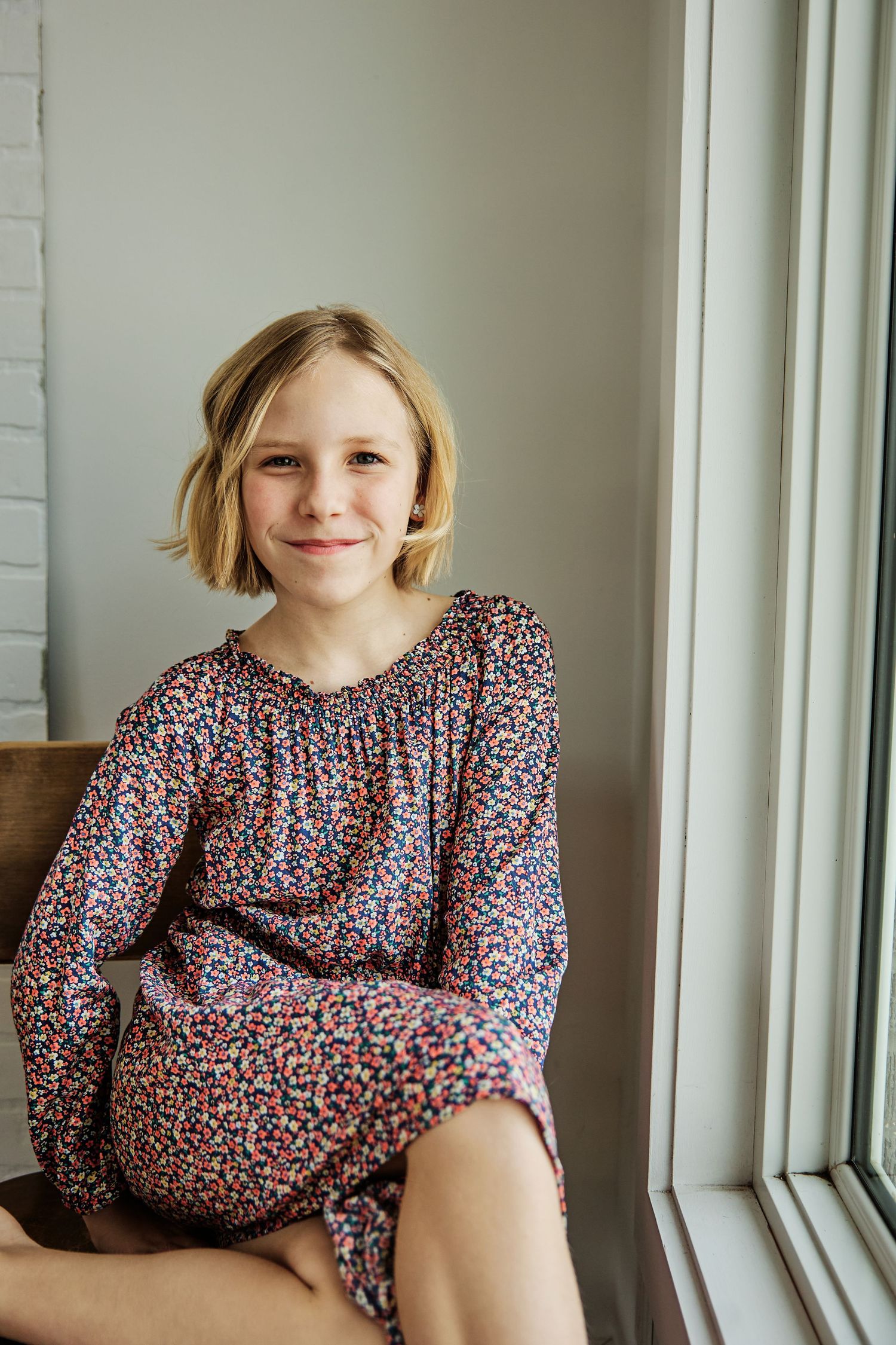 A series of window seat portraits showing someone in a floral print dress.