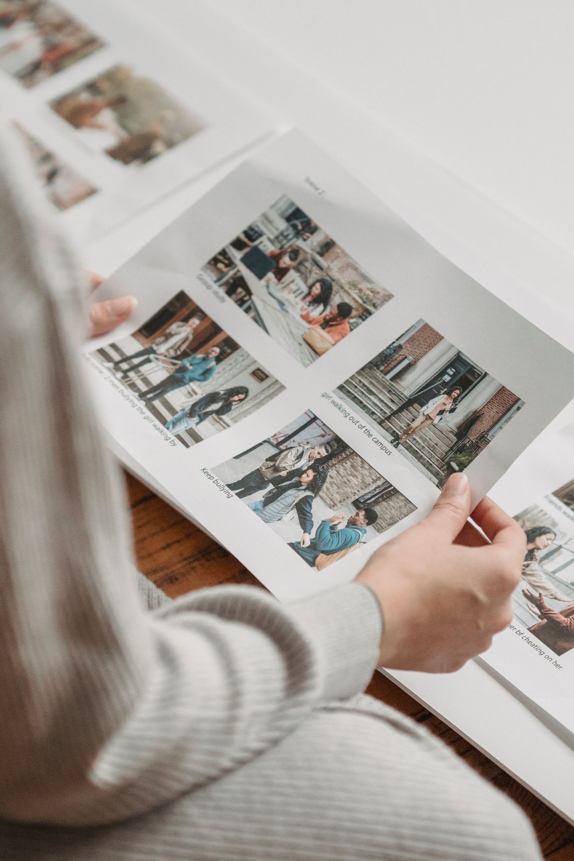 Hands turning pages of a photo album containing lifestyle photographs.